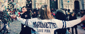 Student facing a crowd, wearing a Marquette sweatshirt