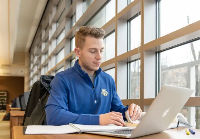 student does homework using laptop