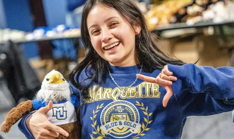 Students holding and eagle plushie