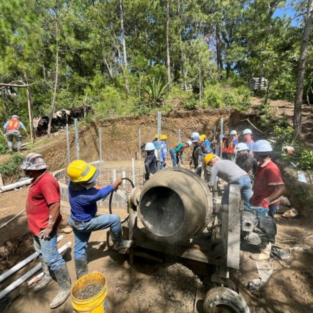 students and community members collaborating on a water tank installation