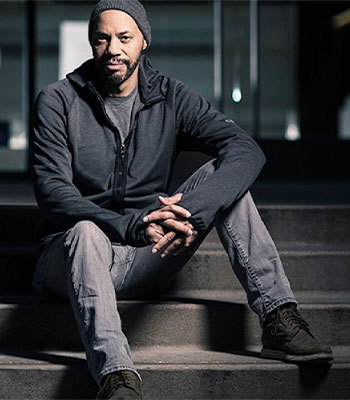 Portrait of John Ridley sitting on steps. 