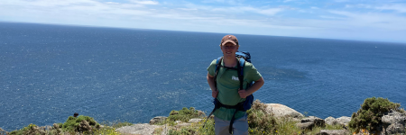 student posing in front of an ocean view