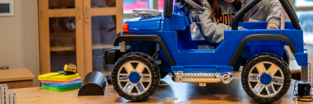 student working on a modified ride-on car for children