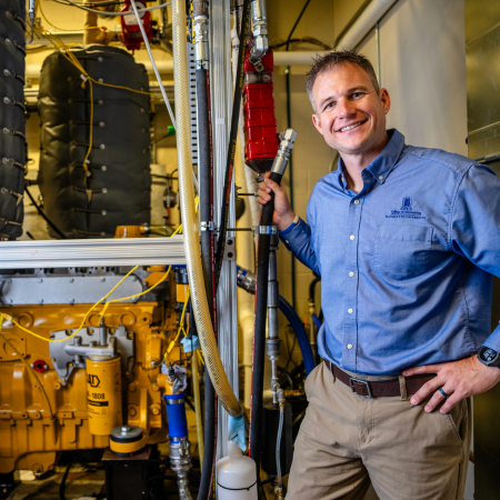 Dr. Adam Dempsey posing with engine technology