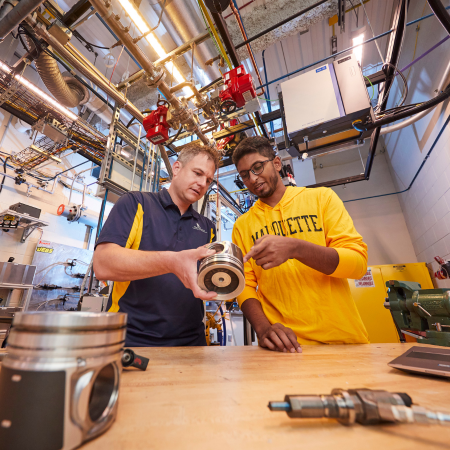 faculty member explaining a mechanical device to a student