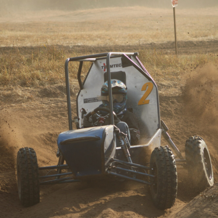 off-road racing vehicle driving over dirt