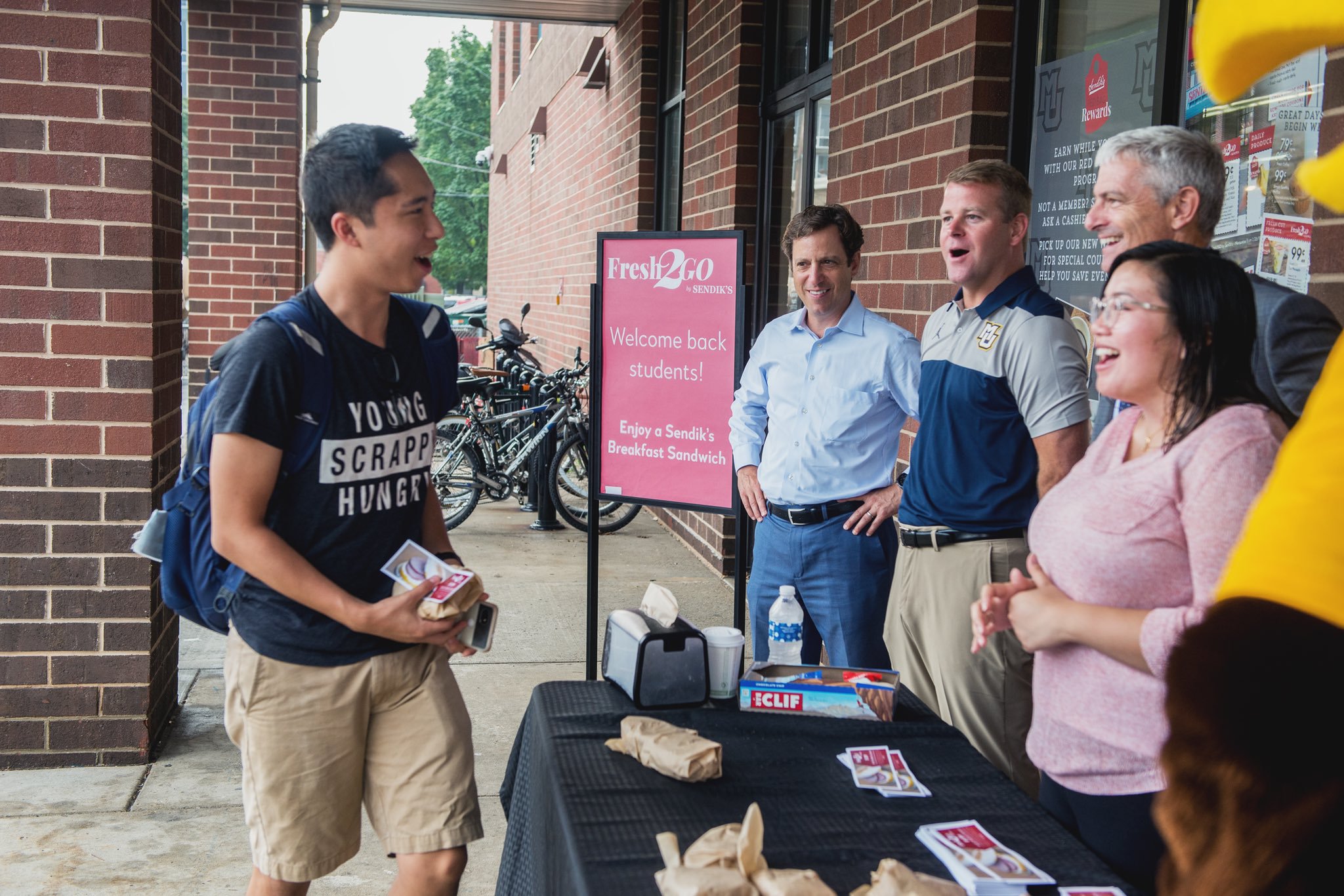 University president, head men's basketball coach handing out breakfast sandwiches on the first day of classes, 2018