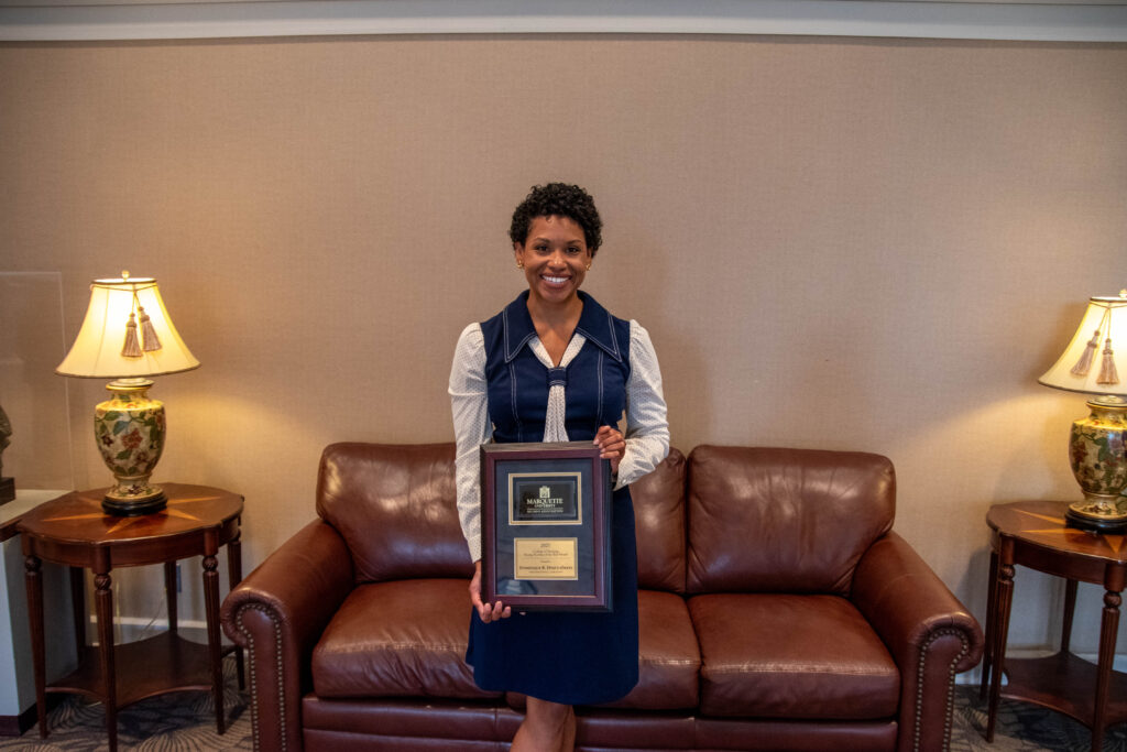 Dominique Hyatt-Oates holding an award.