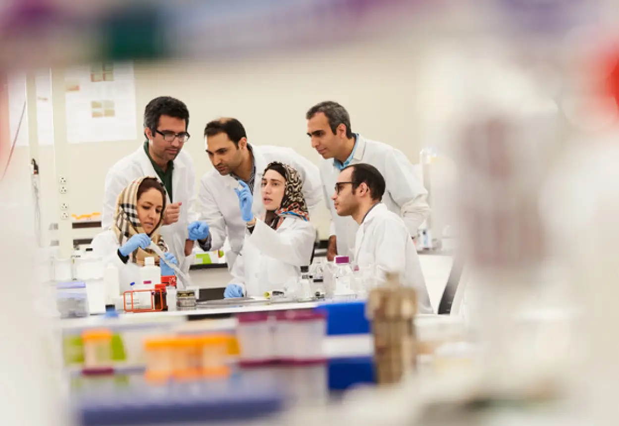 A group of students with faculty working in a science lab. 