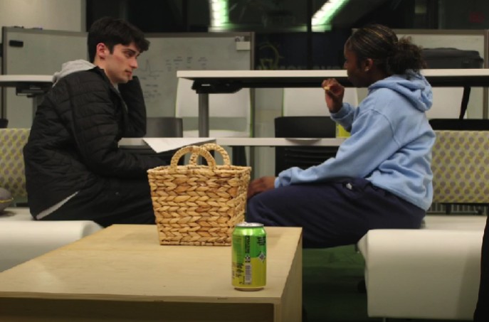 two young adults sitting across from each other talking