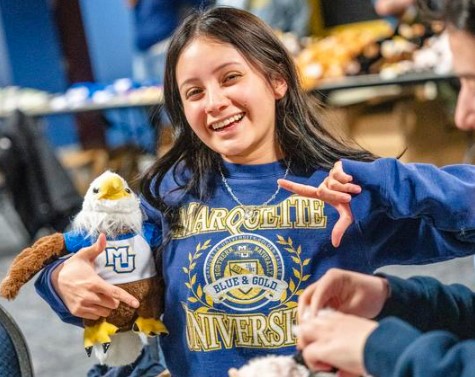 Student holding golden eagle stuffed animal